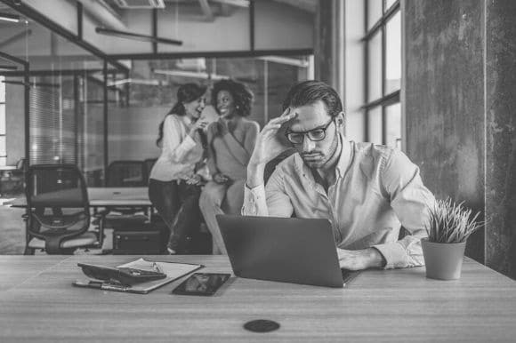 Employees engaging in workplace bullying and laughing at another worker