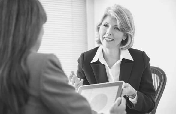 An accounting clerk discussing financial data with her colleague.