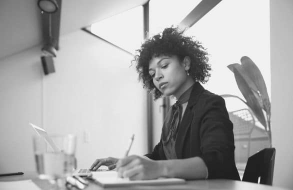 Bookkeeper crunching some numbers while sitting at her desk.