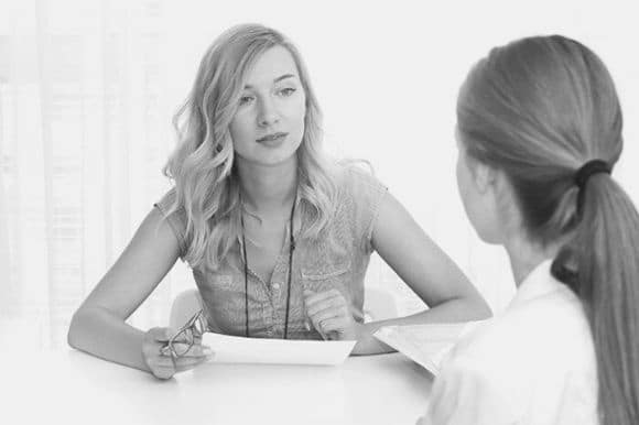 Manager with solid communication skills meeting with one her employees.