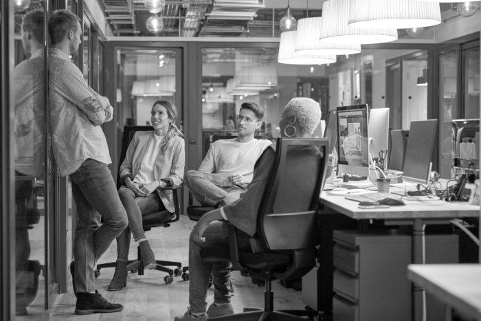 A group of employees having a conversation in the office.