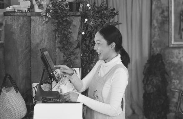 An hourly worker at the cash register of a retail shop.