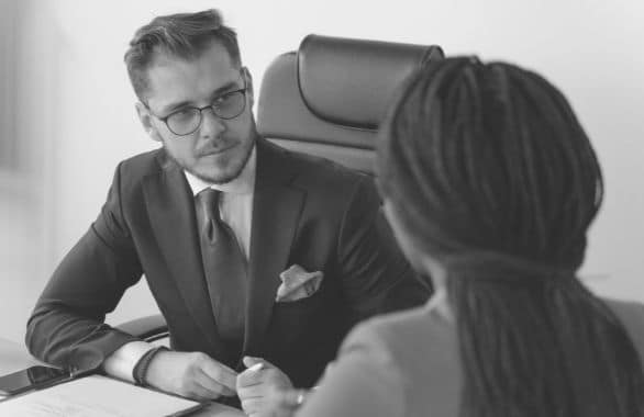 Hiring manager interviewing a job candidate at his desk.