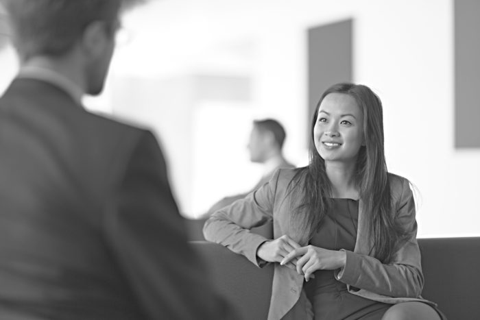 A young professional sitting down and doing a job interview with a hiring manager.