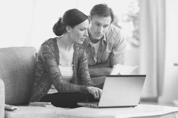 Managers sitting in front of a laptop computer, conducting a reference check.