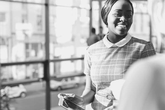 A happy employee is being recognized by her manager for a job well done.