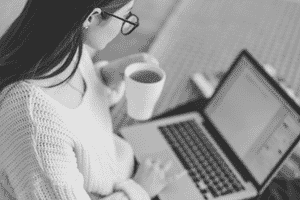 Woman drinking a coffee at laptop