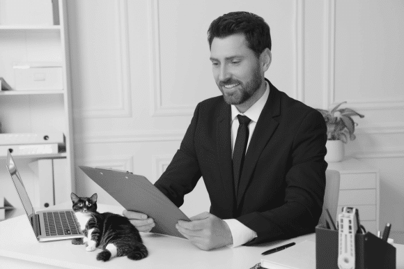 A dyslexic man reviews some writing he has had support with, his kitten provides moral support.