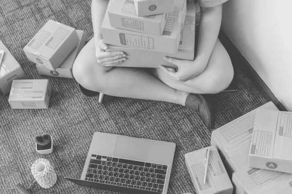 A woman sits cross legged with boxes pf produce