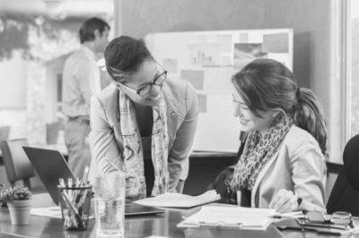 Administrative assistant discussing work with coworker