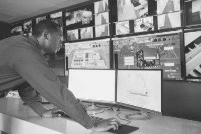 Security guard checking monitors in office